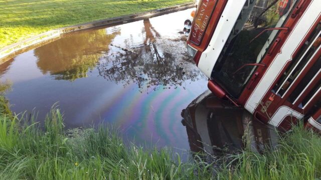 Vrachtwagen met mest in de sloot